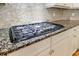 Close-up of gas cooktop and granite countertops in a modern kitchen at 2141 Abby Ne Ln, Atlanta, GA 30345