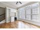 Living room features large windows, hardwood floors, neutral paint, built in bar, and adjacent staircase at 2141 Abby Ne Ln, Atlanta, GA 30345