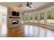 Spacious living room with a stone fireplace, hardwood floors, large windows and modern ceiling fan at 2141 Abby Ne Ln, Atlanta, GA 30345