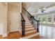 Open staircase featuring black metal spindles, hardwood floors, and a view into an open living area with fireplace at 2141 Abby Ne Ln, Atlanta, GA 30345