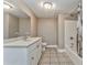 Bathroom featuring tile floor, vanity, white cabinets, a sink, toilet, mirror, and shower at 3229 Summer Stream Nw Ln, Kennesaw, GA 30152