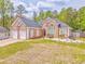 Well-kept brick home with a two-car garage and beautiful landscaping against a backdrop of green trees at 3229 Summer Stream Nw Ln, Kennesaw, GA 30152