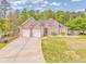 Beautiful brick home with a two-car garage, a lush lawn, and mature trees, creating a serene setting at 3229 Summer Stream Nw Ln, Kennesaw, GA 30152