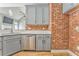 Open concept kitchen with gray cabinets, stainless steel appliances and a brick accent wall at 3229 Summer Stream Nw Ln, Kennesaw, GA 30152