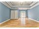 Large main bedroom with decorative tray ceiling, ceiling fan, light blue walls and hardwood floors at 3229 Summer Stream Nw Ln, Kennesaw, GA 30152