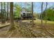Landscaped backyard featuring a stone creek, a wooden bridge, and a view of the house with a spacious deck above at 4270 Parnell Rd, Marietta, GA 30062