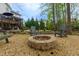 Backyard with a stone fire pit and chairs, with mature trees and a multi-level deck visible in the background at 4270 Parnell Rd, Marietta, GA 30062