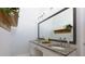 Granite countertop bathroom featuring a double vanity, framed mirror, and decorative wall shelves at 4270 Parnell Rd, Marietta, GA 30062