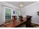 Well-lit dining room with large windows, hardwood floor, and decorative light fixture at 4270 Parnell Rd, Marietta, GA 30062