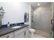 Bathroom featuring granite countertop, framed mirror, vanity, toilet, and tiled walk-in shower at 559 Southland Cir, Canton, GA 30115