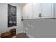 Well-lit laundry room with patterned tile flooring, white cabinets, and utility connections at 559 Southland Cir, Canton, GA 30115