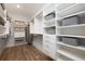Well-organized walk-in closet featuring built-in shelves, drawers, hanging rods, and light hardwood floors at 559 Southland Cir, Canton, GA 30115