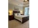 Spacious bedroom with a tray ceiling, carpet floors, and a large wooden bed with decorative pillows at 611 Parkside Village Nw Way, Marietta, GA 30060