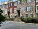 Exterior elevation of townhomes featuring brick and stone with black shutters in The Gates at Parkside Village at 611 Parkside Village Nw Way, Marietta, GA 30060
