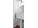 Neat powder room featuring a pedestal sink, round mirror, and modern lighting at 611 Parkside Village Nw Way, Marietta, GA 30060
