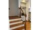 Elegant staircase with wooden railings and black iron spindles, next to a built-in bookcase at 611 Parkside Village Nw Way, Marietta, GA 30060