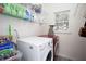 Functional laundry room equipped with modern washer, dryer, and storage shelves at 131 Helmswood Sw Cir, Marietta, GA 30064