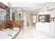 Beautiful bathroom featuring dual sinks, jacuzzi tub with marble, and a frameless glass shower with natural light at 131 Helmswood Sw Cir, Marietta, GA 30064
