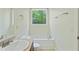 Well-lit bathroom featuring a soaking tub under a window with wooded views and a vanity at 168 Ellis Dr, Conyers, GA 30012