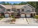 Beautiful townhome featuring brick facade, attached garage, and landscaped front yard under a bright sky at 168 Ellis Dr, Conyers, GA 30012