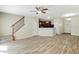 Open-concept living room with kitchen view, hardwood floors, staircase, ceiling fan, and white trim at 168 Ellis Dr, Conyers, GA 30012