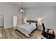 Comfortable bedroom featuring wood floors, a grey bed frame, neutral walls, and a modern chandelier at 1965 Winnstead Pl, Loganville, GA 30052
