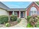 Up close, beautifully landscaped front entrance with yellow flowers, leading to the front door at 1965 Winnstead Pl, Loganville, GA 30052