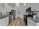 Modern kitchen with granite countertops, stainless steel appliances, and wood flooring at 1965 Winnstead Pl, Loganville, GA 30052