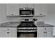Close-up of gas range and granite countertops in modern kitchen at 1965 Winnstead Pl, Loganville, GA 30052
