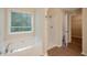 Bathroom with a large tub, walk-in shower, and large window with green view at 272 Ascott Ln, Woodstock, GA 30189