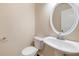 Stylish half bathroom features a pedestal sink, toilet, and a decorative mirror adding charm to the space at 272 Ascott Ln, Woodstock, GA 30189
