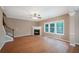 Bright living room featuring a corner fireplace, hardwood floors, ceiling fan and an abundance of natural light from the large windows at 272 Ascott Ln, Woodstock, GA 30189