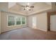 Main bedroom with tray ceiling, fan, neutral paint, and carpet, with an ensuite bathroom at 272 Ascott Ln, Woodstock, GA 30189