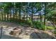 Backyard features a firepit with a wooded perimeter and privacy fence at 890 Muirfield Rdg, Marietta, GA 30068