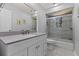 Updated bathroom with a quartz countertop, framed mirror, and shower-over-tub with glass doors at 890 Muirfield Rdg, Marietta, GA 30068