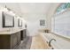 Primary bathroom featuring dual sinks, soaking tub, and neutral tile at 989 Vendue Dr, Lawrenceville, GA 30044