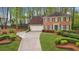 Traditional two-story home featuring a well-manicured lawn and a paved driveway at 989 Vendue Dr, Lawrenceville, GA 30044