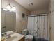 Cozy bathroom with a single sink vanity, patterned walls and a shower with a floral curtain at 2962 Moorings Pkwy, Snellville, GA 30039