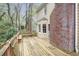 View of the home's wood deck and outdoor seating area with trees and brick chimney at 2962 Moorings Pkwy, Snellville, GA 30039