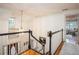 Upstairs hallway features hardwood floors, a modern light fixture, and access to the bedrooms at 2962 Moorings Pkwy, Snellville, GA 30039