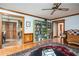 Open living room with hardwood floors, a ceiling fan, and access to the kitchen and the hallway at 2962 Moorings Pkwy, Snellville, GA 30039