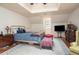 Spacious main bedroom with a tray ceiling, bedside table, a ceiling fan, and hardwood floors at 2962 Moorings Pkwy, Snellville, GA 30039
