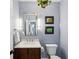 Charming powder room features a dark wood vanity, marble countertop, and decorative mirror at 4152 Club Ne Dr, Atlanta, GA 30319