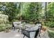 Backyard patio with comfortable seating area overlooks tranquil pond with waterfall feature surrounded by mature trees at 5515 Cross Gate Ct, Sandy Springs, GA 30327