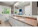 Charming bathroom featuring double sinks, granite countertop, and a bright window, creating a relaxing and inviting space at 5515 Cross Gate Ct, Sandy Springs, GA 30327