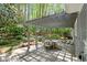 Rear stone patio with dining area and pergola is surrounded by mature trees and lush landscaping at 5515 Cross Gate Ct, Sandy Springs, GA 30327