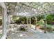 Charming backyard patio with stone floor, pergola, and outdoor seating surrounded by lush landscaping and mature trees at 5515 Cross Gate Ct, Sandy Springs, GA 30327