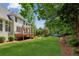 Lush backyard featuring mature landscaping, a covered porch, and a well-kept lawn at 7020 Weybridge Dr, Cumming, GA 30040