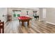 Spacious finished basement with a classic pool table and hardwood-style flooring at 7020 Weybridge Dr, Cumming, GA 30040