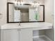 Bathroom features a vanity with white countertop and framed mirror, next to enclosed shower at 7020 Weybridge Dr, Cumming, GA 30040